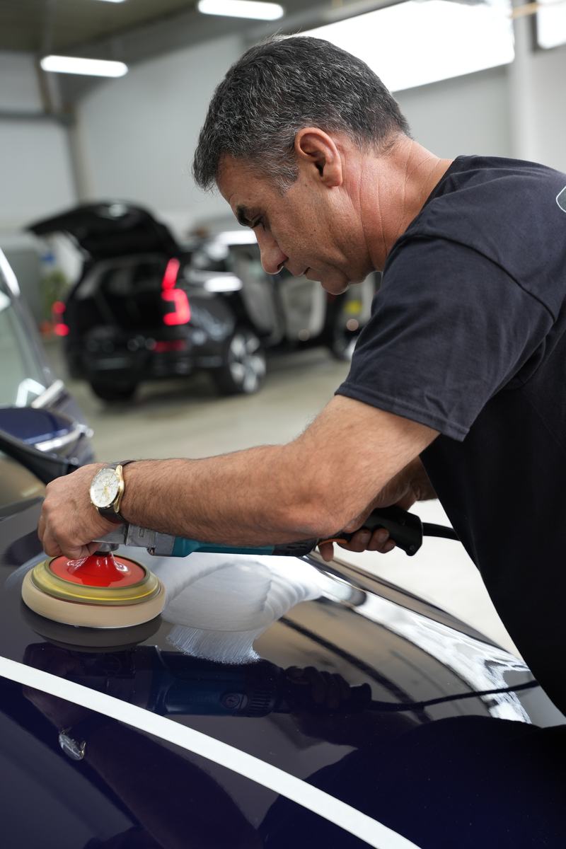 Lackpolitur mit der Poliermaschine an der Motorhaube