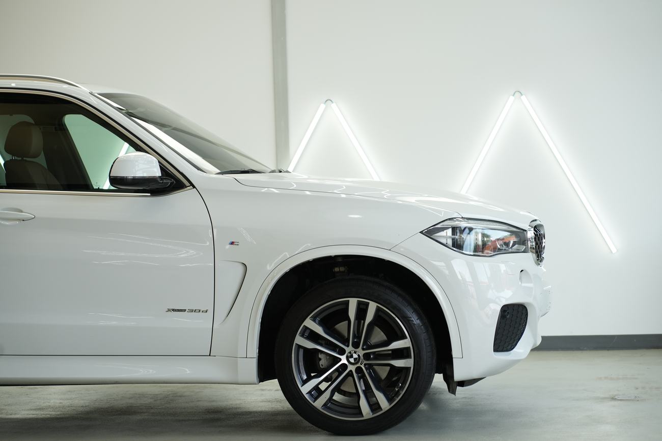Weißer BMW X5 nach der Fahrzeugaufbereitung, Lack und Felgen im Detail