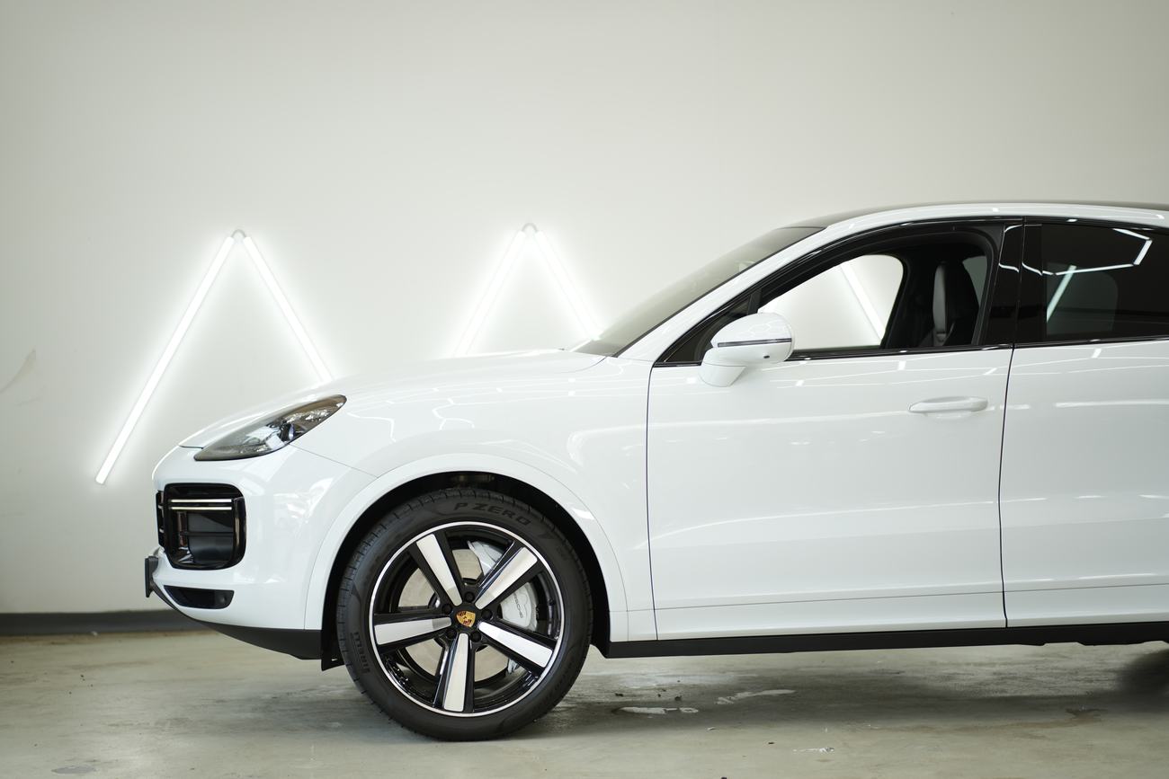 Front und Felge eines weißen Porsche Cayenne im Detail