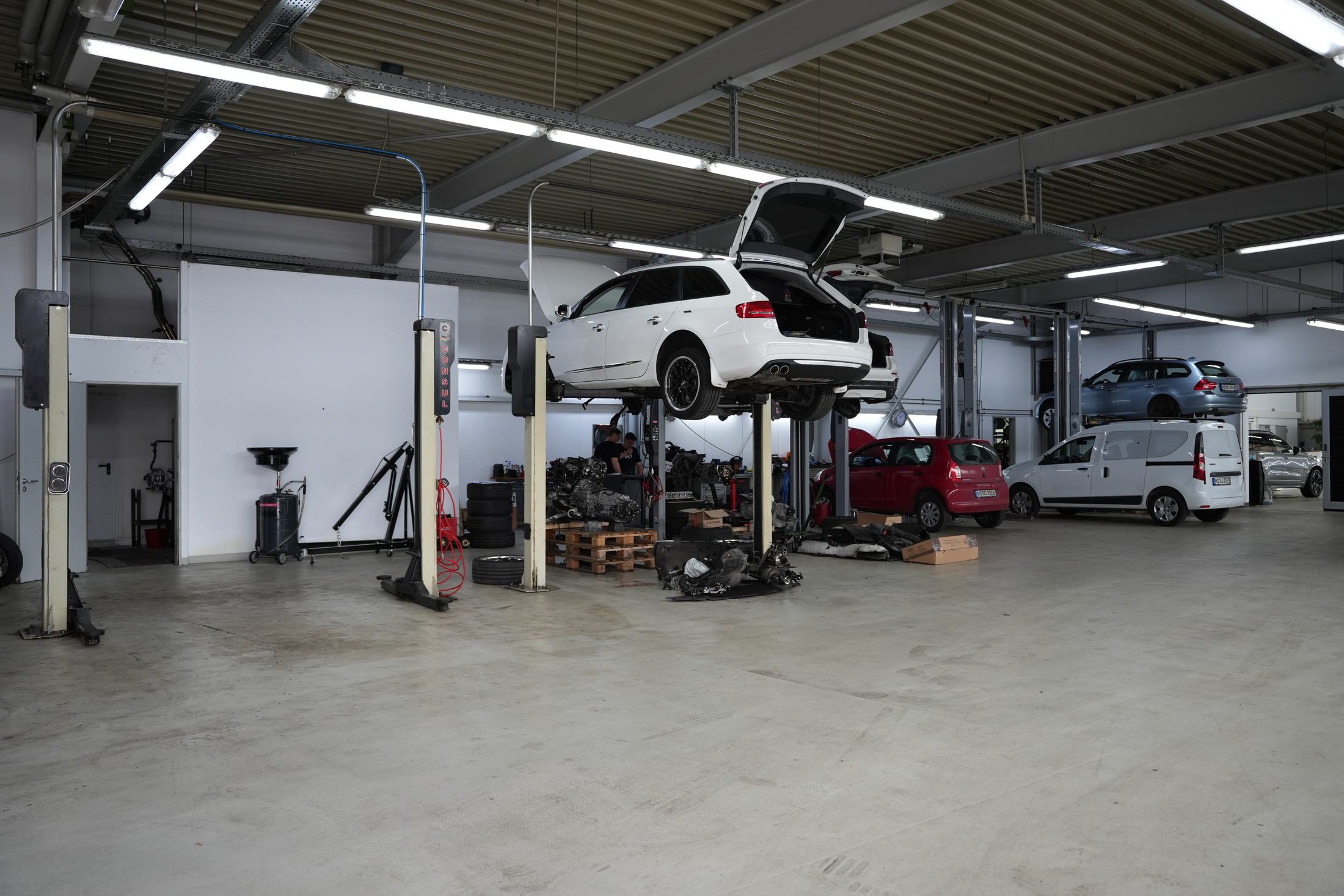 Hobbywerkstatt in München Trudering: Halle mit mehreren Hebebühnen und Fahrzeugen