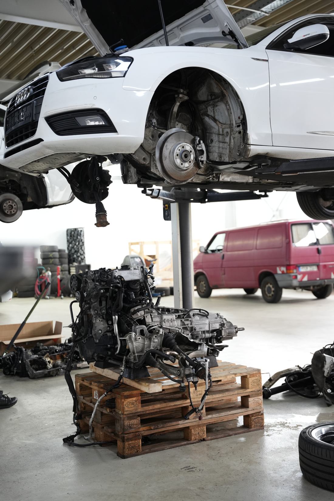 Fahrzeug auf der Hebebühne, ausgebauter Motor auf der Palette – Arbeit in der Hobbywerkstatt